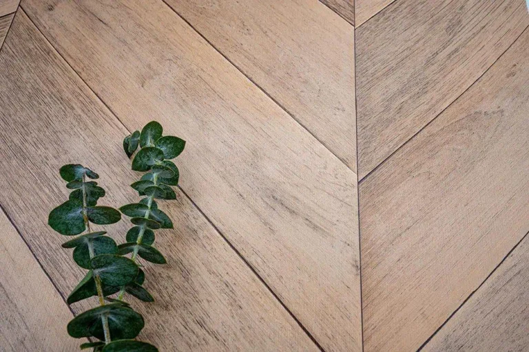 Rośliny w zestawieniu z folią Chevron Oak (Dąb w jodełkę) podkreślają jej organiczne ciepło. Jasny dąb z lekko przydymionym tonem nadaje wnętrzom przytulności, zachowując elegancki styl. To folia drewnopodobna z fakturą idealna do nowoczesnych i klasycznych aranżacji.